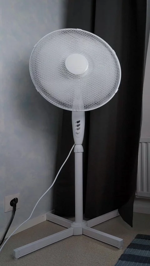 Close up of floor fan by window Stock Footage 342989820