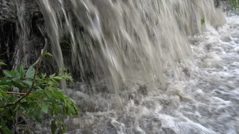 Close-up of the flow of muddy bubbling water flowing into the river. Video stock 111714911