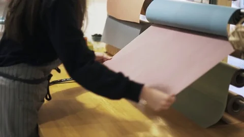 Close up of flower shop assistant cutting paper with scissors 스톡 동영상 76202361