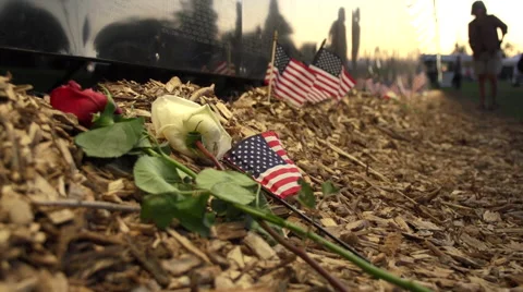 Close up of flowers and flags next to Vietnam Wall That Heals. Stock Footage 47392319