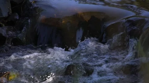 Close-Up of Flowing Stream Water Cascading Over Mossy Rocks in a Tranquil N.. Stock Footage 346549741