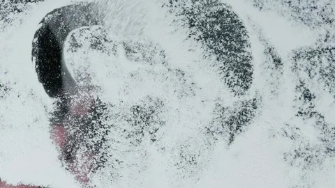 Close-up of fluffy brush on a snow-covered glass surface erases romantic heart Stock Footage 261186237