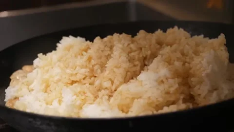 Close-Up of Fluffy Rice Being Stir-Fried in a Wok Video stock 347687964