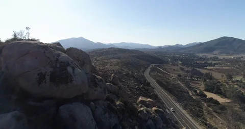 Close fly over rocks looking over road in Pine Valley California drone aerial 4K Stock Footage 111308208