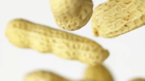 Close-up flying peanuts in slow motion on the white background Video stock 148552291