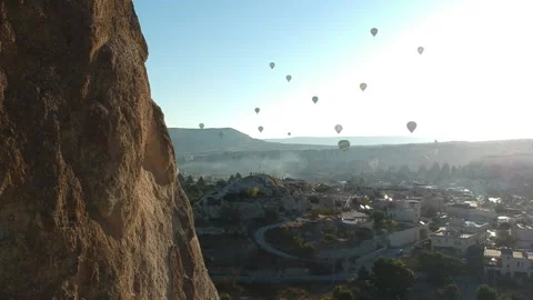 Close Flying to Rocks and a view of Balloons in Cappadocia Stock Footage