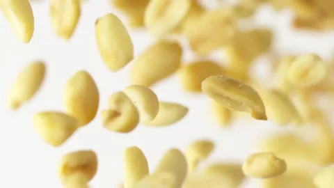 Close-up flying salted peanuts in slow motion on the white background Video stock 148552543