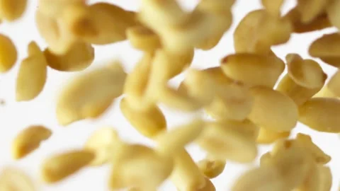 Close-up flying salted peanuts on the white background slow motion Video stock 148552398