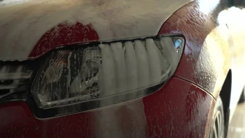 Close-up of foam dripping down the headlamp during a car wash. no people. Stock Footage 143003618