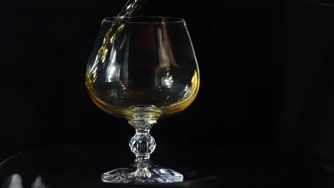 Close-up, foaming champagclose-up, someone pours brandy into a cognac glass Stock Footage 80851510