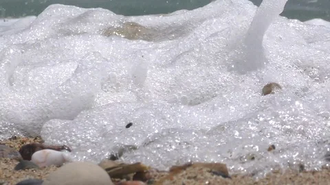 Close foamy sea wave washes pebbles on beach and rolls back Stock Footage 103300166