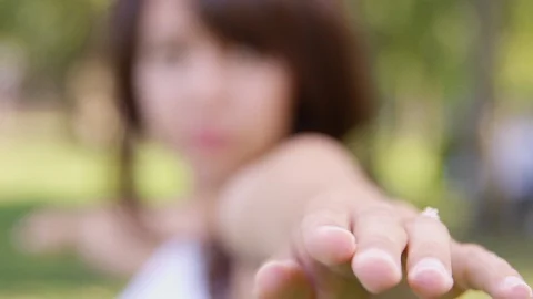 Close Up - Focus in and out of a young woman doing yoga outside - shot on RED Stock Footage 124925803