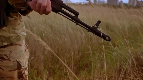 Close-up focus automatic gun in the hands of strong camouflaged soldier Video stock 97728836