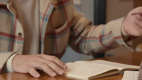 Close-up focus on a notebook and hands during a study group discussion Stock Footage 323175013