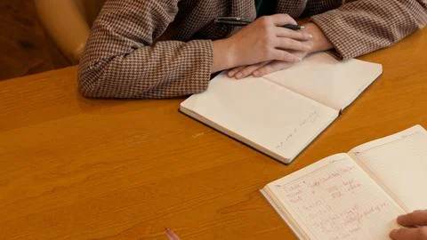 Close-up focus on a notebook and hands during an indoor business meeting Stock-Fotos