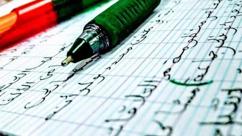 Close up in focus on pens on a notebook with beautiful Arabic writing. Stock Photos