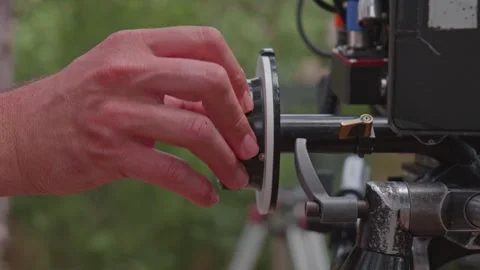 Close-Up of Focus Puller Hands Turning Follow Focus Wheel on Film Set Stock Footage 346603331