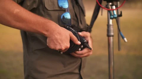 Close-up of the focus puller's hands at work, turning the focus wheel Stock Footage 221915288