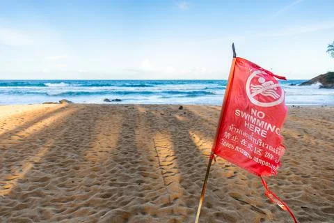 Close focus on red flag for warning not to swim due to dangerous beach area. Stock Photos