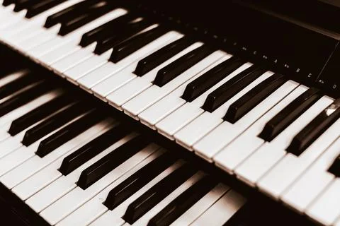Close focus on upper row of piano with warm tone of black and white. Stock Photos