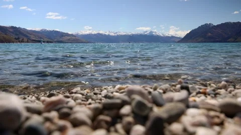 Close focus on waves at Lake Hawea infront of snowcapped mountrains Stock-Footage 328134563