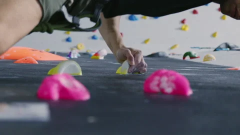 Close-Up of Focused Climber Navigating Low Angle on Indoor Climbing Wall with Stock Footage 276999754