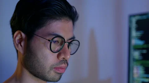 Close-up of a focused male programmer reviewing complex code on a computer. Stock Footage 310589106