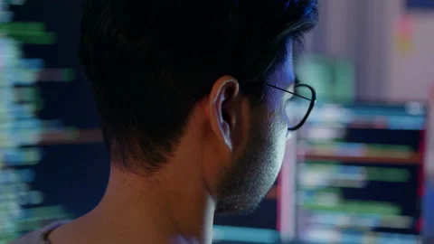 Close-up of a focused male programmer reviewing complex code on a computer. Stock Footage 310589121