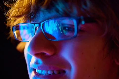 Close-up of focused man in glasses looking at computer screen, analyzing stock Stockfoto's
