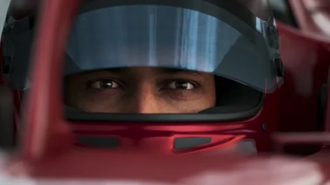 Close-up of a focused pilot driver in a red racing car, preparing for a race Stock Footage 300991076
