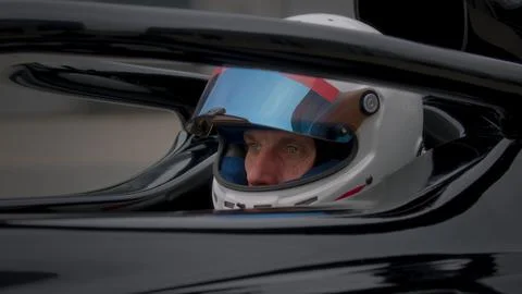 Close-up of a focused pilot driver in a red racing car preparing for a race Stock Photos