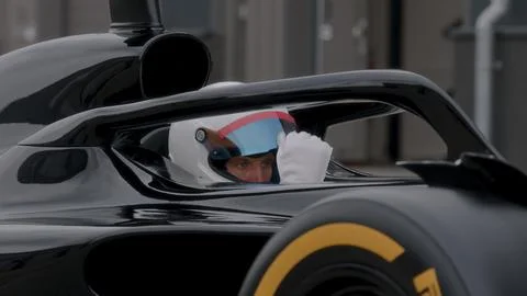 Close-up of a focused pilot driver in a red racing car preparing for a race Stock Photos