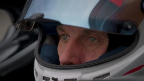 Close-up of a focused pilot driver in a red racing car preparing for a race Stock Photos