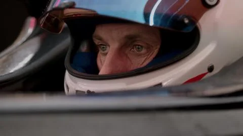 Close-up of a focused pilot driver in a red racing car preparing for a race Stock Photos