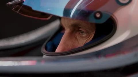 Close-up of a focused pilot driver in a red racing car preparing for a race Stock Photos