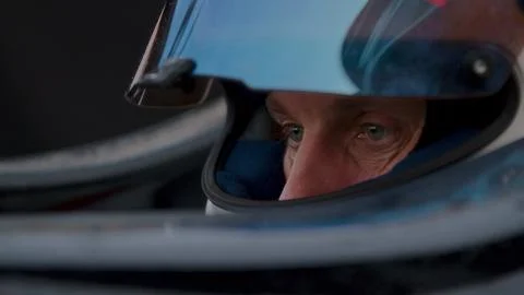 Close-up of a focused pilot driver in a red racing car preparing for a race Stock Photos