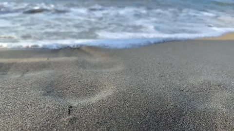 Close up focused sandy beach blurred sky sunlight. Beach sand close up white foa Stock Footage 211806363