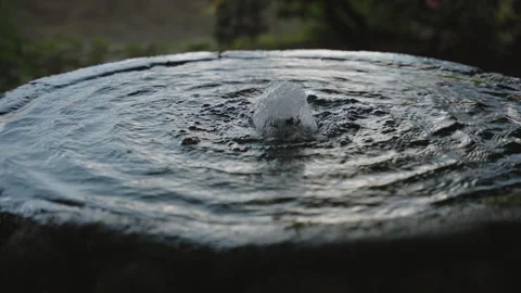 Close-up, focused shot of water bubbling from the center of a circular stone Stock-Footage 336205039
