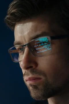 Close up of focused software engineer wearing glasses, analyzing code on his 스톡 사진