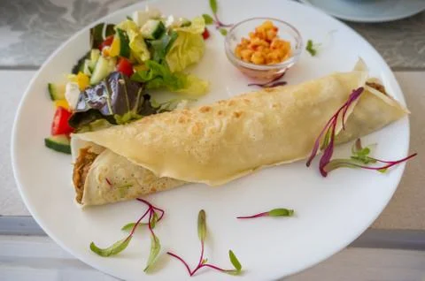 Close up of folded crepe with pulled pork and salad on the side with corn sal Stock Photos