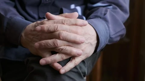 Close-Up of Folded Hands Resting on a Knee in a Relaxed Pose Stock Footage 309095395