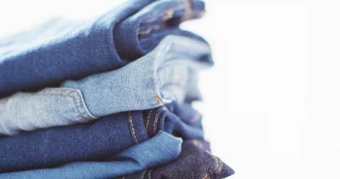Close up of folded jeans with different shades on white background with copy Stock Footage 339271607