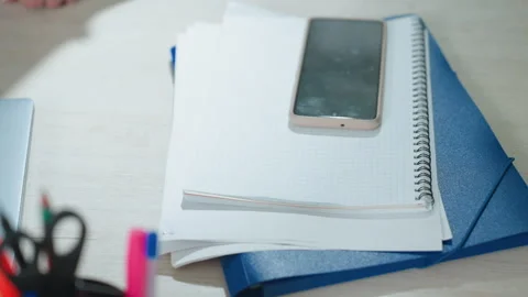 Close Up of Folder Phone and Notebook on Office Table with Open Laptop Stock Footage 310801252