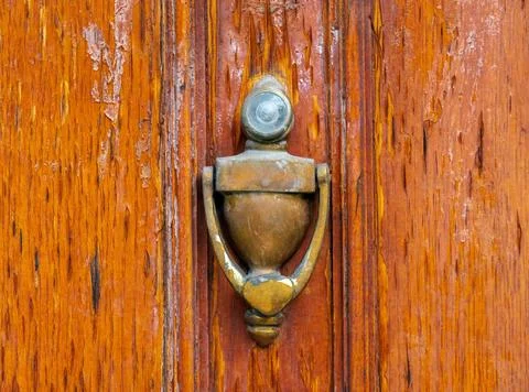 Close-up of a folding knocker on the background of a weathered wooden door... Stock Photos