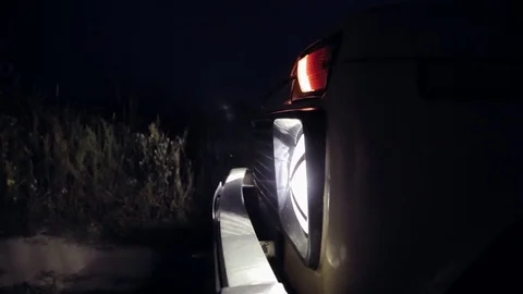 Close up of font of the car with headlights turned on at night, panning effect. Stock Footage 78626194
