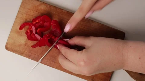 Close-Up of food preparation. slicing red bell pepper on wooden cutting board. Video stock 317106970