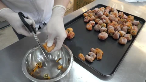 Close-up of Food Processor in Gloves Cutting Dried Persimmons into Metal Bowl Stock Footage 345291726