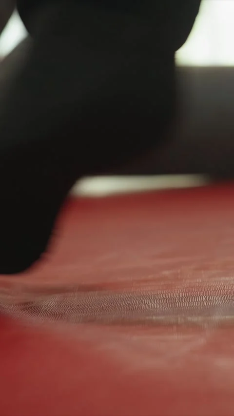 Close up of foot in black sock performing subtle movements on red textured Stock Footage 345545897