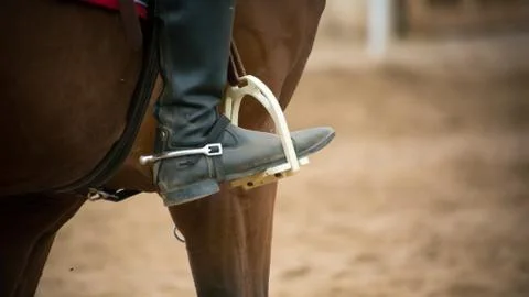 Close up of a foot inside the stirrups 库存照片