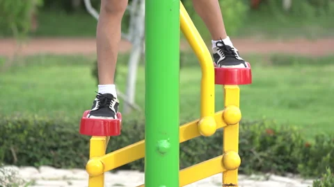 Close up foot of kid playing and exercise on outdoor public gym equipment Stock Footage 135540294